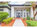 Inviting front entrance with double doors, decorative columns, and manicured landscaping at 8023 Canyon Lake Cir, Orlando, FL 32835