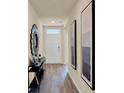 Inviting hallway with light walls, wood floor and modern decorative mirrors at 1068 Clay Blvd, Tavares, FL 32778