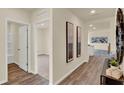 Hallway with wood-look floors, neutral paint, and art leading to a bedroom with carpet at 1076 Clay Blvd, Tavares, FL 32778