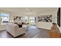 Bright living room with hardwood floors, modern decor, and sliding glass doors for natural light at 1076 Clay Blvd, Tavares, FL 32778