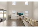 Bright living room with soaring ceilings, large windows, stylish furniture and hardwood floors at 1103 Silo Dr, St Cloud, FL 34771