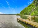 Scenic view of a wooden dock extending into a tranquil lake under a blue sky at 1150 Carmel Cir # 301, Casselberry, FL 32707