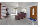 Bright living room with tile flooring, sliding glass doors, and natural wood door at 1219 Helen St, Apopka, FL 32703