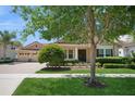 Charming single-story home with a manicured lawn, mature trees, and a paver driveway, radiating curb appeal at 15698 Marina Bay Dr, Winter Garden, FL 34787