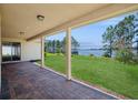 A covered outdoor patio offering stunning lake views and a brick-paved floor for relaxed outdoor living at 15698 Marina Bay Dr, Winter Garden, FL 34787