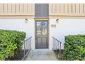 Inviting front door with glass panes, landscaped entrance with manicured hedges, and clear unit number at 200 Maitland Ave # 52, Altamonte Springs, FL 32701