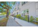 Condominium exterior with lush landscaping, iron fence and sidewalk at 204 E South St # 2061, Orlando, FL 32801
