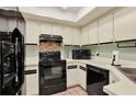 Efficient kitchen with sleek black appliances and ample cabinet space at 237 S Wilderness Pt, Casselberry, FL 32707