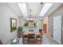 Bright dining area with skylights, modern chandelier, and stylish wood-look flooring, adjoining to kitchen at 239 Hill St # 239, Casselberry, FL 32707