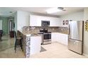 Well-lit kitchen with stainless steel appliances, stylish backsplash, and counter seating at 2812 Club Cortile Cir # A, Kissimmee, FL 34746