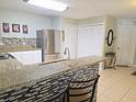 Bright kitchen featuring granite countertops, tiled backsplash, and stainless steel refrigerator at 2812 Club Cortile Cir # A, Kissimmee, FL 34746