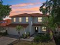 Two-story home at dusk featuring a red tile roof and well-maintained landscaping at 332 Summer Place Loop, Clermont, FL 34714