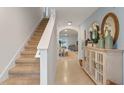 Inviting foyer featuring tile floors, a staircase, and decorative furniture pieces at 3471 Costello Cir, Winter Haven, FL 33884