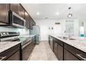 A modern eat-in kitchen with stainless steel appliances, granite countertops, and dark wood cabinetry at 4231 Swan St, Haines City, FL 33844