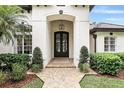 Close-up showcasing the elegant arched entryway and ornate wrought iron front door of a beautiful home at 4517 Old Carriage Trail, Oviedo, FL 32765