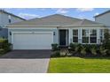 Charming single-Gathering home boasting a brick driveway, 2-car garage, and lush green lawn at 5648 Cedar Chase Dr, St Cloud, FL 34771