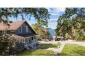 Lovely blue home with a cozy porch, offering a peaceful view of the street and waterfront, shaded by mature trees at 609 W Osceola St, Clermont, FL 34711