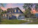 Inviting blue two-story home with a covered porch and picturesque sunset views, creating a serene ambiance at 609 W Osceola St, Clermont, FL 34711