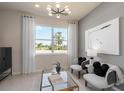Inviting sitting area with a large window, plush chairs, decorative pillows and neutral decor at 6324 Dew Drop Loop, St Cloud, FL 34771