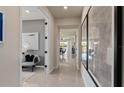 Hallway featuring sleek, glossy floors, modern artwork, and an open view to the dining area at 6324 Dew Drop Loop, St Cloud, FL 34771