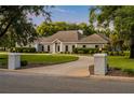 Elegant single-story home boasts a circular driveway, manicured lawn, and inviting curb appeal at 8368 Rambling River Dr, Sanford, FL 32771