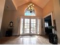 Grand foyer featuring high ceilings, tile flooring, a chandelier, and a double-door entrance with large windows at 8935 Jonathan Manor Dr, Orlando, FL 32819