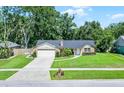 Charming single-story brick home with a well-manicured lawn and mature trees at 1013 Glensprings Ave, Winter Garden, FL 34787