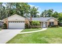 Charming brick home featuring manicured landscaping, a lush lawn, and a welcoming entrance at 1013 Glensprings Ave, Winter Garden, FL 34787
