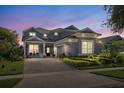 Charming two-story home with landscaped yard and paver driveway at twilight at 7837 Bostonian Dr, Winter Garden, FL 34787