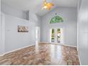 Bright living room showcasing tile floors, vaulted ceilings, and French doors leading to the backyard, inviting relaxation and entertainment at 9301 Echo Run, Orlando, FL 32817