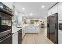 Bright kitchen features stainless appliances, white cabinetry, quartz countertops, and hardwood floors with a seamless open floor plan at 110 Tedworth Ct, Longwood, FL 32779