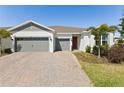 Charming single-story home featuring a brick driveway, two-car garage, and well-maintained landscaping at 15173 Willow Ridge Dr, Montverde, FL 34756