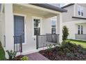 Close-up of a charming front porch with a railing and detailed landscaping at 16484 Silver Brook Way, Winter Garden, FL 34787