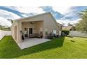 Covered patio with comfortable seating, ceiling fan, and views of the expansive backyard at 16843 Cedar Run Dr, Orlando, FL 32828
