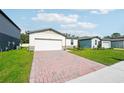 Attractive single-story house with a brick driveway, well-manicured lawn, and clean, neutral facade at 4709 Jasmine Cir, Leesburg, FL 34748