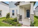 Inviting porch with stone pillars and manicured landscaping leading to a charming blue front door at 5235 Passion Flower Way, Winter Garden, FL 34787