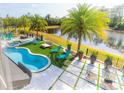 Aerial view of a beautiful kidney-shaped pool, spa, and patio overlooking a tranquil pond at 6550 Cartmel Ln, Windermere, FL 34786