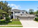 Attractive two-story house with a three-car garage, lush green lawn, and neatly trimmed shrubbery at 10033 Hart Branch Cir, Orlando, FL 32832