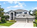 Elegant two-story home boasting a spacious three-car garage and lush greenery at 10033 Hart Branch Cir, Orlando, FL 32832