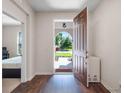 Inviting foyer featuring an open doorway, hardwood floors, and a view of the landscaped front yard at 12188 Ryegrass Trl, Orlando, FL 32824