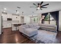 Open-concept living room and kitchen featuring hardwood floors, a ceiling fan, and recessed lighting at 12188 Ryegrass Trl, Orlando, FL 32824