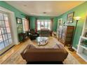 Charming living room featuring hardwood floors, turquoise walls, and a glass coffee table at 1236 Illinois St, Orlando, FL 32803
