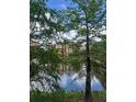Exterior lake view through the trees of the community building at 12539 Floridays Resort Dr Dr # 208D, Orlando, FL 32821