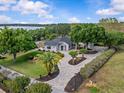 Stunning aerial view of a landscaped home with a circular driveway and beautiful lawn at 12635 Amber Ave, Clermont, FL 34711