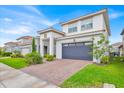 Stunning two-story home boasting a tile roof, brick driveway, well-maintained lawn, and a covered front entrance at 13543 Abberwick Dr, Orlando, FL 32832