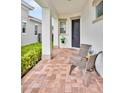 Inviting front porch with brick pavers, two chairs, a small table, and charming curb appeal at 13543 Abberwick Dr, Orlando, FL 32832