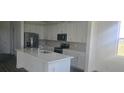 Modern kitchen with stainless steel appliances, white cabinets, an island with a sink, and stylish backsplash at 14599 Crestavista Dr, Clermont, FL 34714