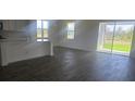 Bright, open-concept living space with dark hardwood floors, lots of natural light, and sliding glass door access to yard at 14599 Crestavista Dr, Clermont, FL 34714