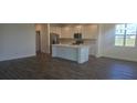 Expansive living space showcasing hardwood floors, an open layout, abundant natural light, and kitchen access at 14599 Crestavista Dr, Clermont, FL 34714