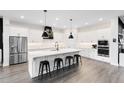 Modern kitchen with stainless steel appliances, large center island with seating, and white cabinetry at 14749 Walcott Ave, Orlando, FL 32827